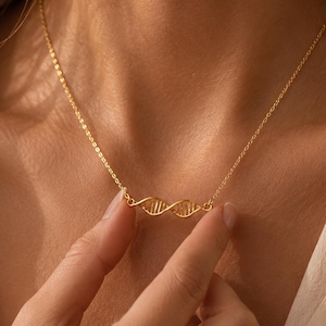 Collar de doble hélice de ADN: colgante de joyería sobre ciencia, biología y genética.