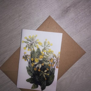 Cartão de felicitações com prímulas, cartão de felicitações com flores amarelas em branco, cartão com prímulas, cartão com pintura em aquarela com prímulas, pintura em aquarela com prímulas.