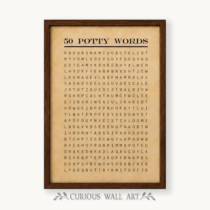 May include: A framed wall art print featuring a word search puzzle titled 50 POTTY WORDS. The print has a beige, parchment-like background with black text and a dark brown wooden frame. The grid contains various letters arranged in rows.