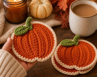 May include: A set of round, orange crochet coasters shaped like pumpkins, each featuring a textured ribbed design, a small green leaf accent at the top, and a cream-colored border. The coasters are crafted with yarn and have a flat, circular form.