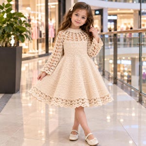May include: A beige long-sleeved dress featuring a crochet knit construction, a round neckline, and an intricate openwork pattern on the bodice, sleeves, and hem. The skirt has a flared silhouette, and the dress is paired with matching beige shoes.