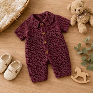 May include: A dark burgundy crochet romper featuring a scalloped collar, short sleeves, and a front button placket with five brown buttons. The garment is crafted with a textured, open-work stitch pattern throughout the bodice and legs.