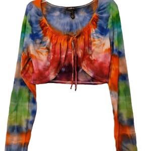 Behold a luxurious tie dye top, boasting long sleeves that add a touch of sophistication to its vibrant design and displaying a harmonious blend of vibrant and vivid colors.This top exudes a vibrant and fashionable aura!