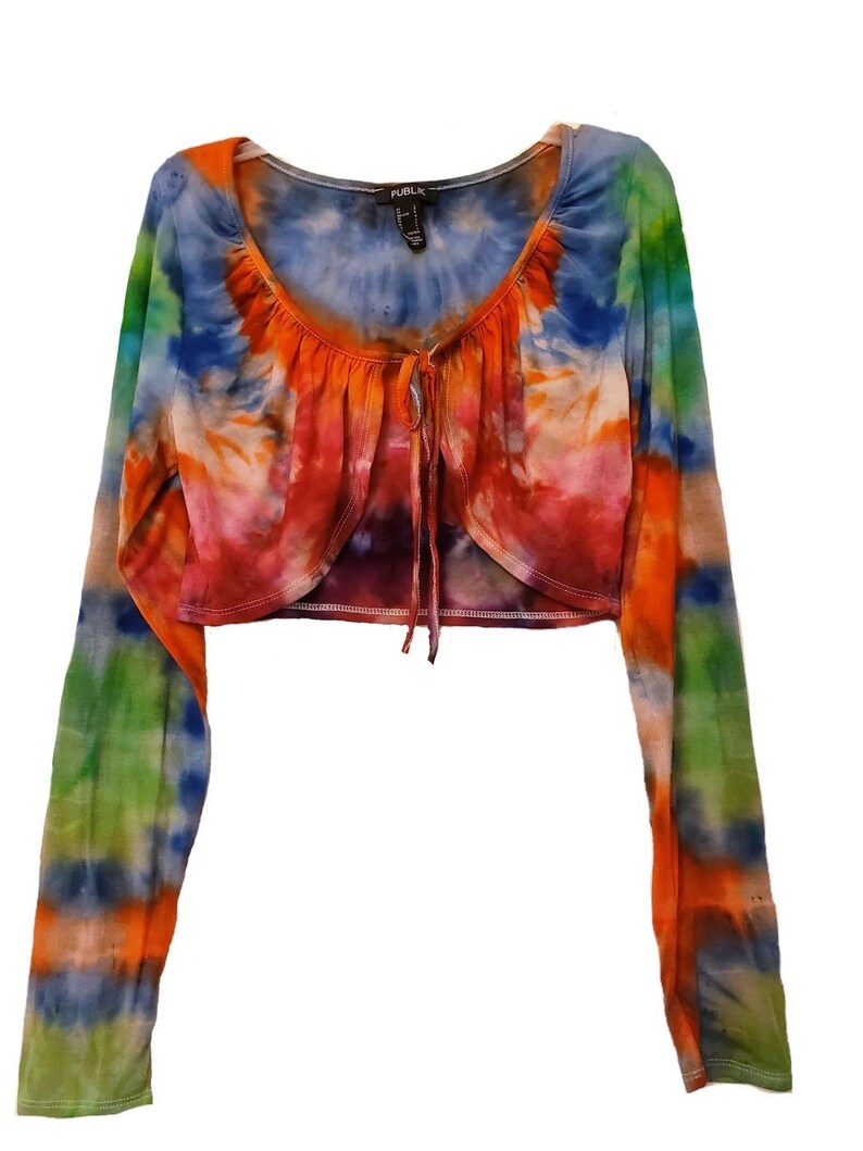 Behold a luxurious tie dye top, boasting long sleeves that add a touch of sophistication to its vibrant design and displaying a harmonious blend of vibrant and vivid colors.This top exudes a vibrant and fashionable aura!