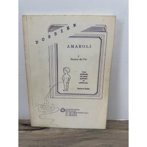 May include: A rectangular off-white booklet titled DOSSIER AMAROLI Source de Vie. The cover features a line drawing of a child urinating into a pool, with the text Une méthode de santé gratuite et millénaire and Docteur Soleil printed below.