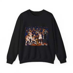 May include: A black long-sleeve sweatshirt featuring a graphic illustration of a basketball team in white and orange uniforms celebrating around a gold trophy, while a player in a black jersey with the number 1 stands facing away from them.