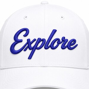 May include: A white baseball cap featuring the word Explore embroidered in a bold, raised blue script font across the front panels. The cap has a structured crown, a curved brim, and small ventilation eyelets on the top of each panel.
