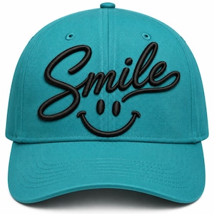 May include: A teal baseball cap featuring the word Smile embroidered in black script across the front, positioned above a black embroidered smiley face graphic. The cap has a structured crown, a curved brim, and matching teal eyelets.