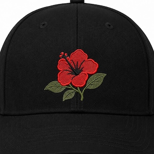 May include: A black baseball cap featuring an embroidered design of a single red hibiscus flower with dark red stamens and three green leaves centered on the front panel. The cap has a structured crown, a curved brim, and stitched eyelets.