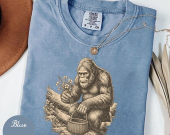Camiseta divertida de Bigfoot con flores silvestres, camiseta para amantes de la naturaleza y el Sasquatch, camiseta con estampado botánico de bosque, regalo para excursionistas, camiseta unisex.