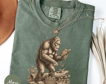 Camiseta divertida de botánico con Bigfoot, camiseta de Sasquatch leyendo un libro, regalo para cazadores de setas, camiseta para amantes de la naturaleza y el bosque, camiseta unisex