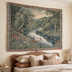 May include: A rectangular woven wall tapestry featuring a detailed landscape scene with a large weeping willow tree, a winding river, and lush forest foliage. The scene includes colorful wildflowers in the foreground and a fringed border.