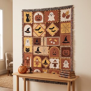 Puede incluir: Una manta tejida con un diseño de patchwork de motivos de Halloween que incluye gatos negros, calabazas, fantasmas, murciélagos, telarañas, sombreros de bruja, espantapájaros y dulces en tonos naranja, marrón, amarillo y crema con flecos.
