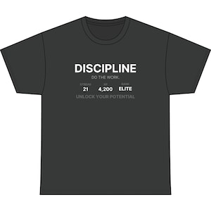 Könnte beinhalten: Ein anthrazitfarbenes Kurzarm-T-Shirt mit weißem Text, der DISCIPLINE DO THE WORK lautet. Darunter zeigt kleiner grauer Text STREAK 21, XP 4,200, RANK ELITE und den Satz UNLOCK YOUR POTENTIAL am unteren Rand des grafischen Designs.