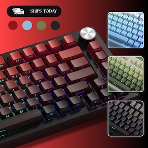 May include: A mechanical keyboard with a black frame, red-to-black gradient keycaps, and a silver circular volume knob. The keyboard features backlit keys and includes three inset panels showing alternative color options in blue, green, and black.