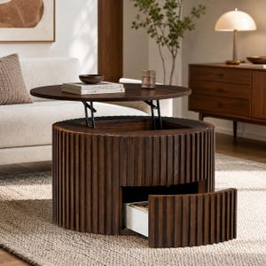 May include: A round, dark brown wooden coffee table with a fluted, slatted exterior design. The table features a lift-top mechanism that reveals an interior storage compartment and a single pull-out drawer with a white interior base.