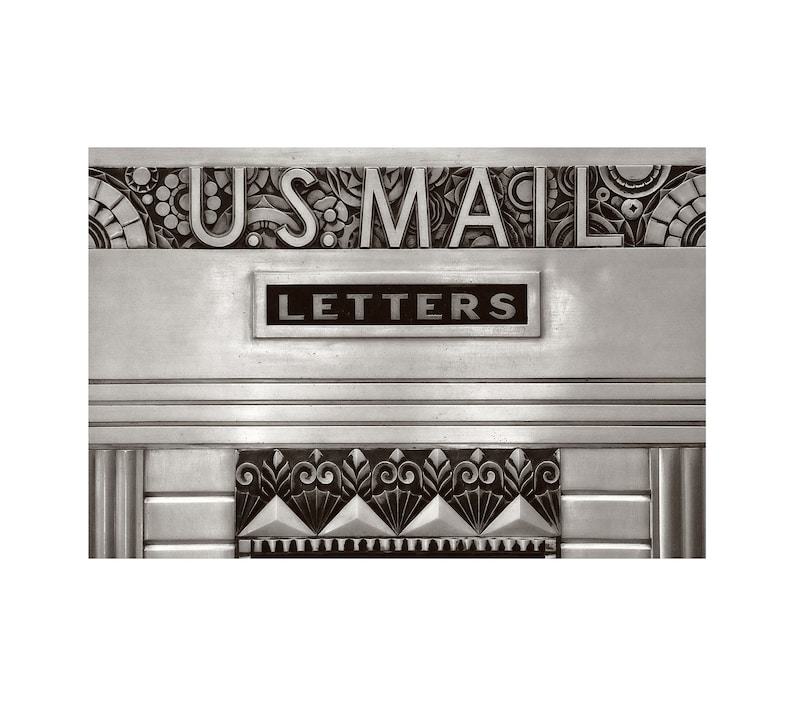 May include: A vintage silver mailbox with the words "U.S. MAIL" and "LETTERS" embossed on it. The mailbox has decorative art deco designs.
