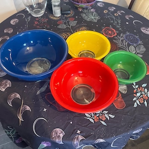 Puede incluir: Un juego de cuatro cuencos redondos para mezclar en colores primarios, que incluye un cuenco azul grande, uno amarillo mediano, uno rojo mediano y uno verde pequeño. Cada cuenco presenta un acabado liso y brillante con un diseño de boca ancha.