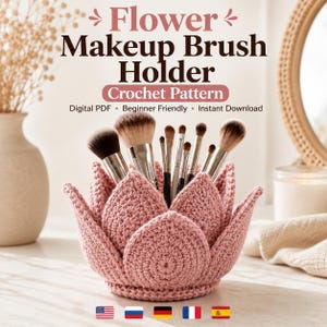 Puede incluir: Un soporte para brochas de maquillaje de ganchillo en color rosa empolvado con varias brochas. El texto dice: Flower Makeup Brush Holder, Crochet Pattern, Digital PDF, Beginner Friendly, Instant Download. El diseño presenta pétalos en capas.