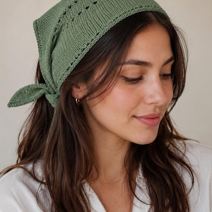 May include: A sage green triangular headscarf crafted from knit fabric, featuring a delicate eyelet lace pattern along the edges and a tie-back closure. The accessory is constructed with a textured knit stitch and finished with a pointed tail.