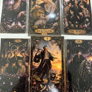 Pode incluir: Um conjunto de seis cartões retangulares estilo tarot com ilustrações artísticas de pessoas em molduras escuras e ornamentadas. Os cartões incluem títulos como King of Cups, Strength, The World, The Lovers, The Fool e Death, com detalhes florais.