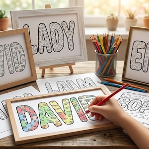 May include: Several rectangular wooden frames display white paper sheets featuring names like DAVID, LADY, EMMA, and SOPHIA in large, bold, outlined block letters filled with various small patterns. A hand uses a red pencil to color the name DAVID.