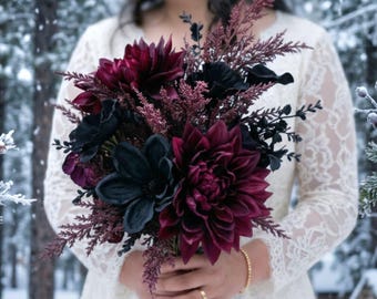 May include: A floral bouquet featuring deep burgundy dahlias, dark black anemones, and feathery maroon foliage. The arrangement is held together in a cluster, showcasing a mix of dark, moody floral textures and rich, saturated color tones.