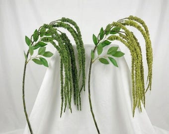 May include: Two artificial hanging amaranth stems with long, cascading green and light green flower spikes. Each stem features a thin brown branch with several pointed green leaves extending from the side of the main stalk.