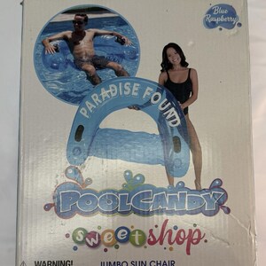 May include: A rectangular product box for a PoolCandy Sweet Shop Jumbo Sun Chair in Blue Raspberry. The box features graphics of a person using the blue inflatable pool chair, the text Paradise Found, and a warning label about pool safety.