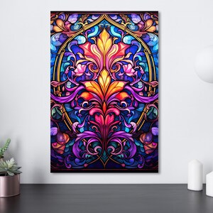 May include: A vibrant stained-glass style artwork featuring a central floral design in shades of orange, red, and purple, surrounded by blue and gold accents. The artwork is displayed on a white wall, adding a touch of color to the room.