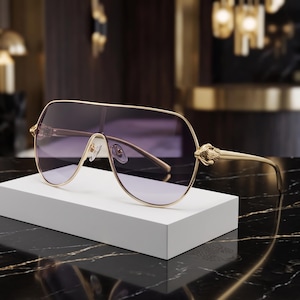 May include: Oversized shield sunglasses featuring a thin gold metal frame and gradient purple lenses. The temples are adorned with a textured gold metal panther head detail at the hinges, and the bridge includes adjustable nose pads.
