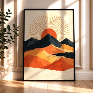 Könnte beinhalten: Ein rechteckiger Wandkunstdruck in einem schwarzen Rahmen mit einer stilisierten Landschaft, die eine große orangefarbene Sonne mit goldenen Strahlen über dunkelblauen Berggipfeln zeigt, geschichtet über orangefarbene und gelbe Hügel.