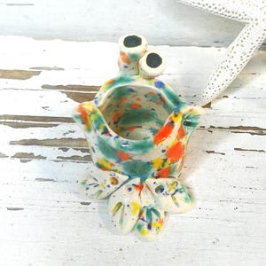 May include: A white ceramic mug with a black handle and the text "But First, Coffee" in a bold, black font. The mug is set against a neutral background, highlighting its simple design.