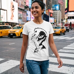 May include: A white short-sleeved t-shirt featuring a black ink-style graphic print of a person's profile on the chest, paired with blue denim jeans that have distressed detailing at the knees and a frayed hemline on the legs.