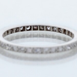 May include: A silver band ring with a row of small diamonds set in a channel setting.