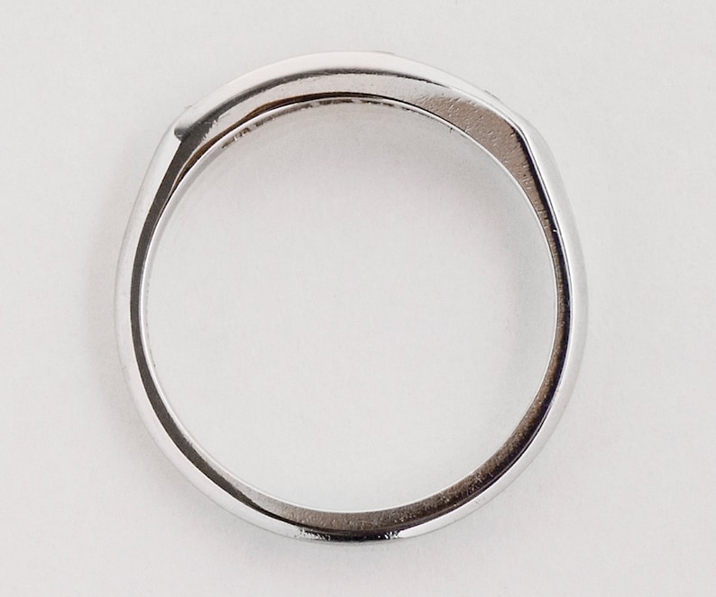 May include: A silver band ring with a smooth, polished finish.