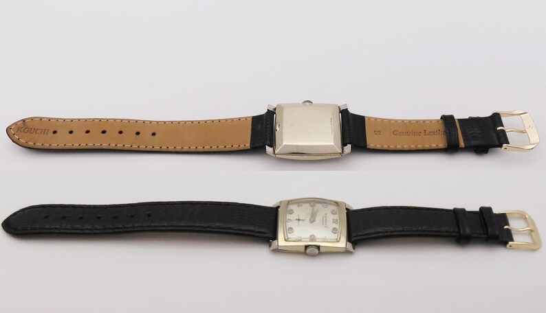 May include: Two vintage wristwatches with rectangular and square silver-toned cases and black leather bands. One watch has a light brown leather band on the inside. The watch faces have a light-colored background with black hands and markers.