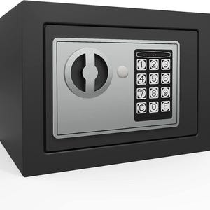May include: A black rectangular security safe featuring a silver-toned front panel. The panel includes a circular rotating handle, a small circular indicator light, and a black digital keypad with numbers one through nine, zero, C, and E keys.