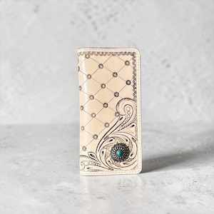 May include: A light beige leather wallet featuring a dark brown embossed diamond grid pattern with small circular accents. The lower right corner displays intricate floral scrollwork and a circular silver-toned concho with a turquoise stone.