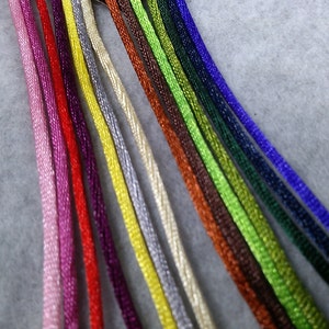 May include: A collection of colorful embroidery floss spools in various shades of pink, red, yellow, green, blue, and brown.