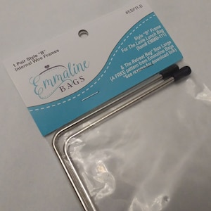 May include: A pair of silver wire frames for a large bag, packaged on a white background with a blue and white label. The label reads "Emmaline Bags" and includes the text "Style "B" Frame for The Luxie Lunch Bag (Item# EMMB-111) & The Retreat Bag* Size Large (A FREE pattern from Emmaline Bags *See reverse for download link)"