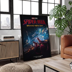 May include: A framed movie poster for Marvel Studios Spider-Man Brand New Day featuring a red and blue costumed figure overlooking a brightly lit city at night. The text reads Spider-Man Brand New Day, Exclusively in Movie Theaters July 31, 2026.