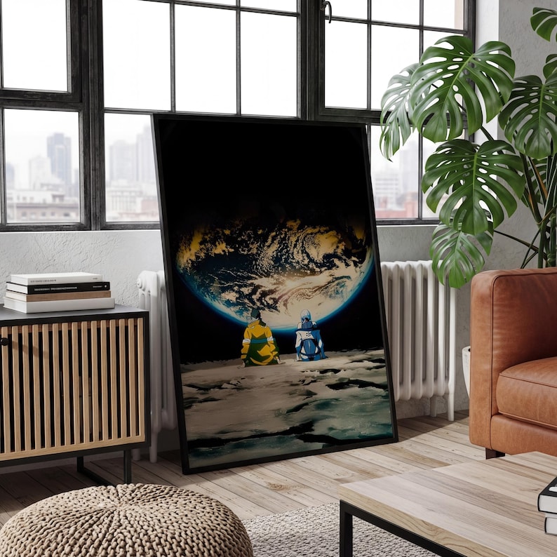 May include: A framed vertical wall art print depicting two figures in yellow and blue jackets sitting on a rocky lunar surface, looking out at a glowing, detailed view of the Earth suspended in the dark expanse of space against a black background.