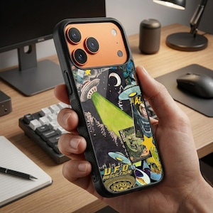 Op de afbeelding: Een zwarte smartphonehoes met een oranje cameramodule en een grafisch achterpaneel met meerdere UFO's, een maansikkel, gele sterren en de tekst U.F.O. ABDUCTION. De hoes heeft een zwarte, getextureerde zijgreep en een glanzende afwerking.