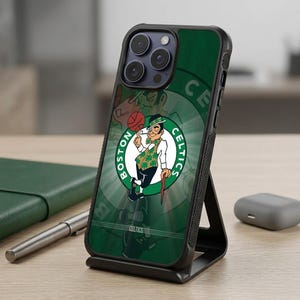 Könnte beinhalten: Eine schwarze Smartphone-Hülle mit dem Logo der Boston Celtics, das einen Cartoon-Kobold mit Pfeife, grüner Weste und Gehstock zeigt. Der Hintergrund ist ein dunkelgrünes kreisförmiges Design mit dem Schriftzug Boston Celtics um die Grafik.