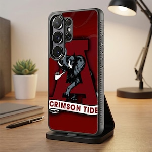 Könnte beinhalten: Eine dunkelrote Smartphone-Hülle mit einem großen Buchstaben A im Hintergrund, einer grauen Elefantengrafik in der Mitte und einem weißen Banner am unteren Rand mit dem Text CRIMSON TIDE in dunkelroten Buchstaben, eingefasst in einen schwarzen Rahmen.
