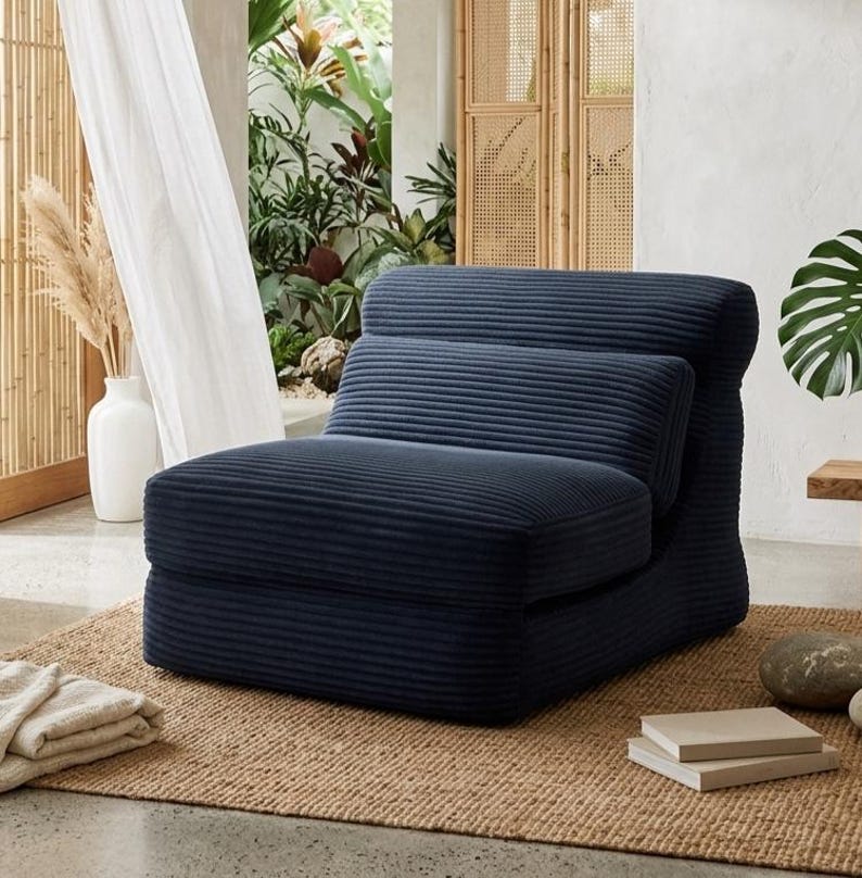 May include: A dark navy blue armless chair upholstered in a textured corduroy fabric. The chair features a low-profile design with a thick, cushioned seat and a separate, integrated backrest cushion, creating a clean and structured silhouette.