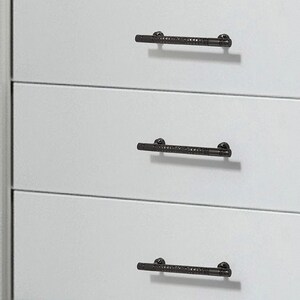 May include: Three matte black drawer pulls with a textured, knurled centre section and smooth ends. Each handle is mounted horizontally onto a flat, light grey surface, featuring two small circular attachment points at the ends of each bar.