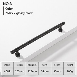 May include: A glossy black cabinet handle, model 6089, featuring a textured, hammered surface. The hardware measures 165mm in length, 14mm in width, and 30mm in height, with a 128mm hole pitch and a weight of 106g. The design includes two cylindrical mounts.