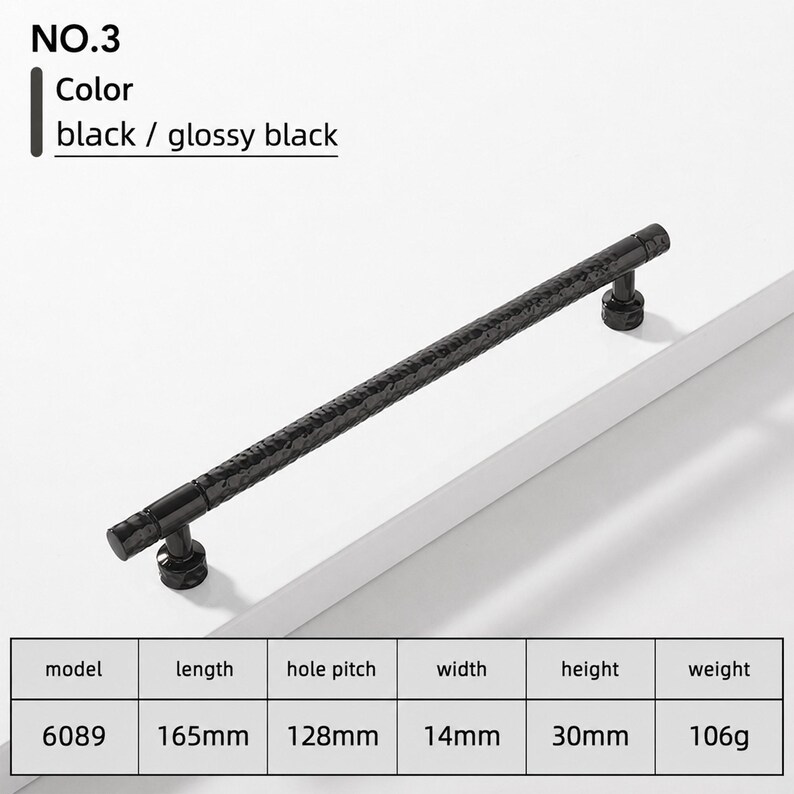 May include: A glossy black cabinet handle, model 6089, featuring a textured, hammered surface. The hardware measures 165mm in length, 14mm in width, and 30mm in height, with a 128mm hole pitch and a weight of 106g. The design includes two cylindrical mounts.